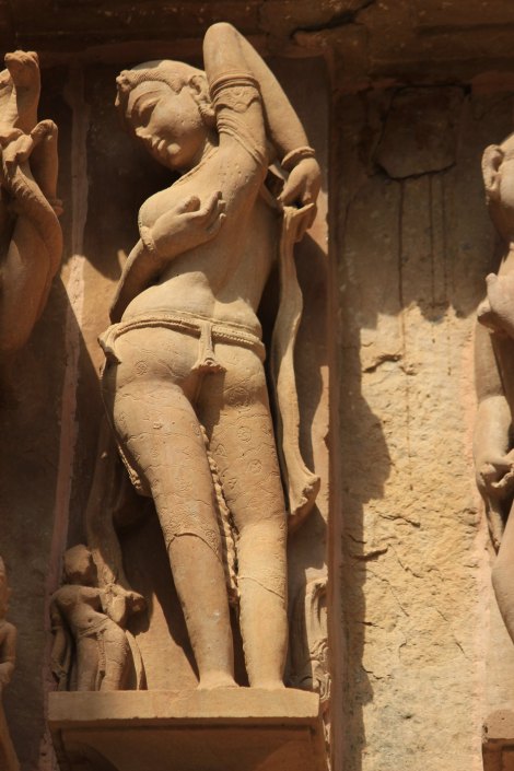 A graceful statue of a Sur suundari, undressing herself, her embroidered finery  and lithe figure beautifully sculpted to perfection